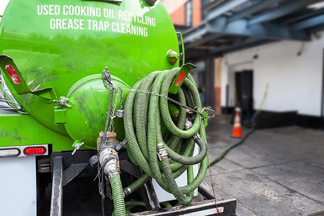 a grease trap being pumped by a sanitation technician in Menlo Park